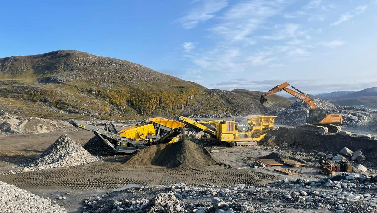 Steinknuseverk og gravemaskin i drift på stort pukkverk