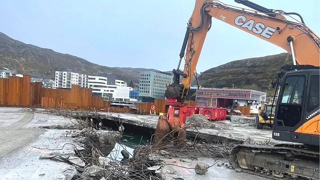 Gravemaskin fjerner betongdekke på anleggsområde