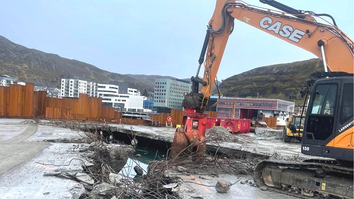 Gravemaskin fjerner betongdekke på anleggsområde